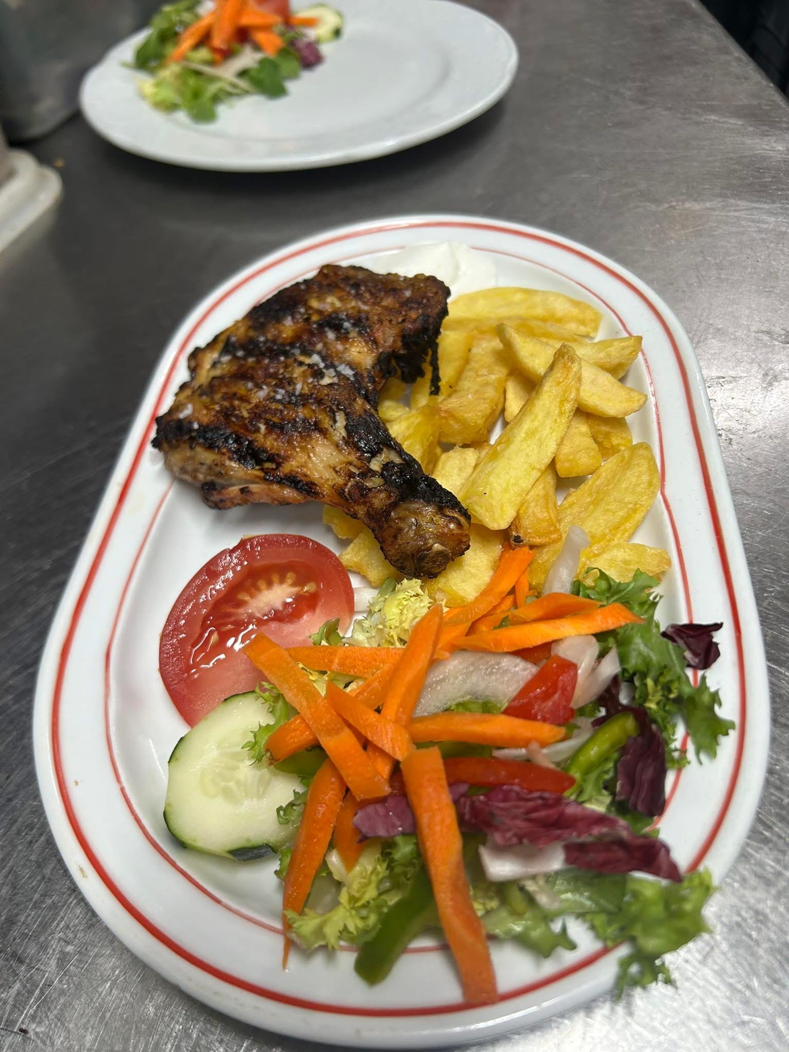 Muslo de pollo a la parrilla con patatas y ensalada